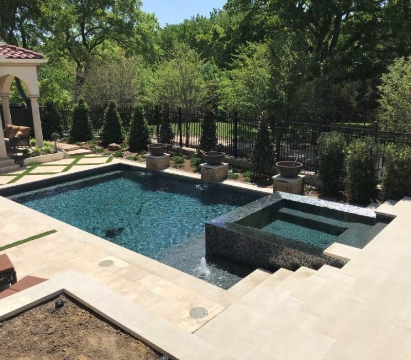 Contemporary geometric swimming pool with integrated black tile spa and travertine decking - Leisure Living Pools modern pool design with Mediterranean pavilion luxury residential construction Dallas Fort Worth Texas